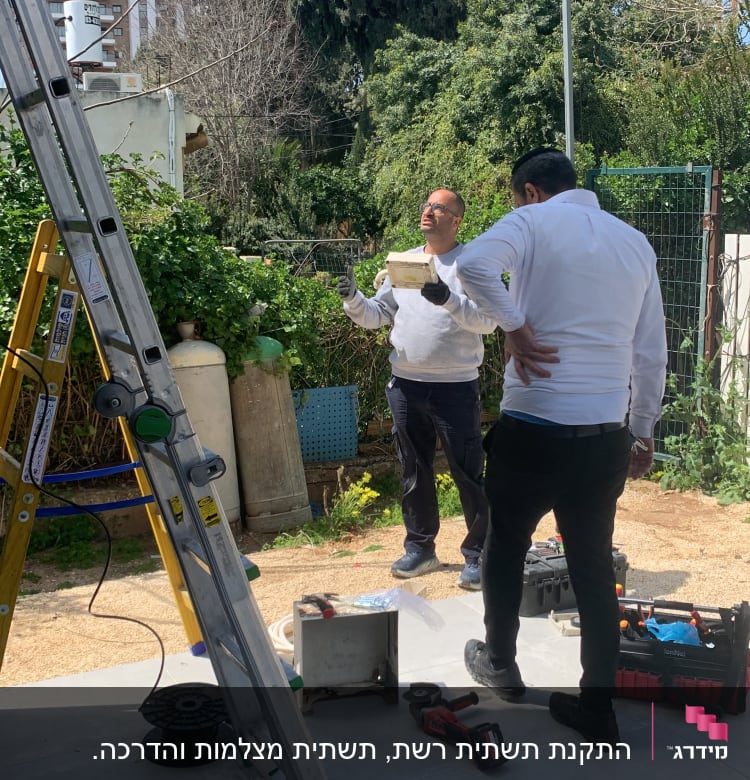 טכנאי רשת עם סולם, כלי עבודה וכבלים בחוץ